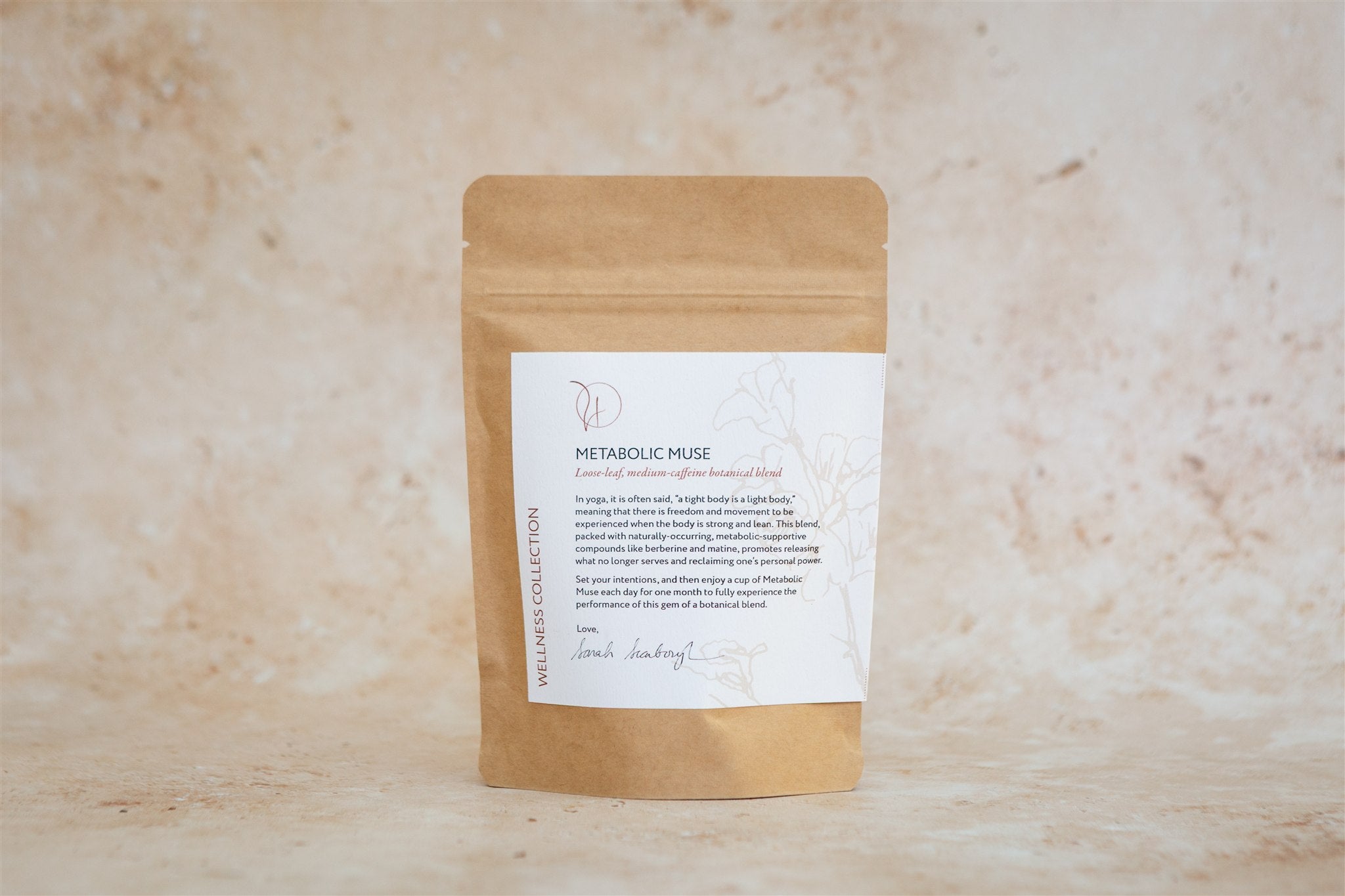 Kraft paper packaging with Metabolic Muse tea blend label on a beige textured background